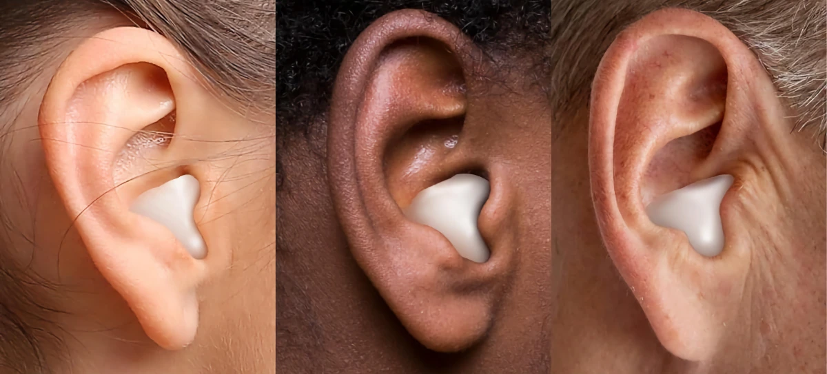 Three different-sized ears with wax earplugs in them.